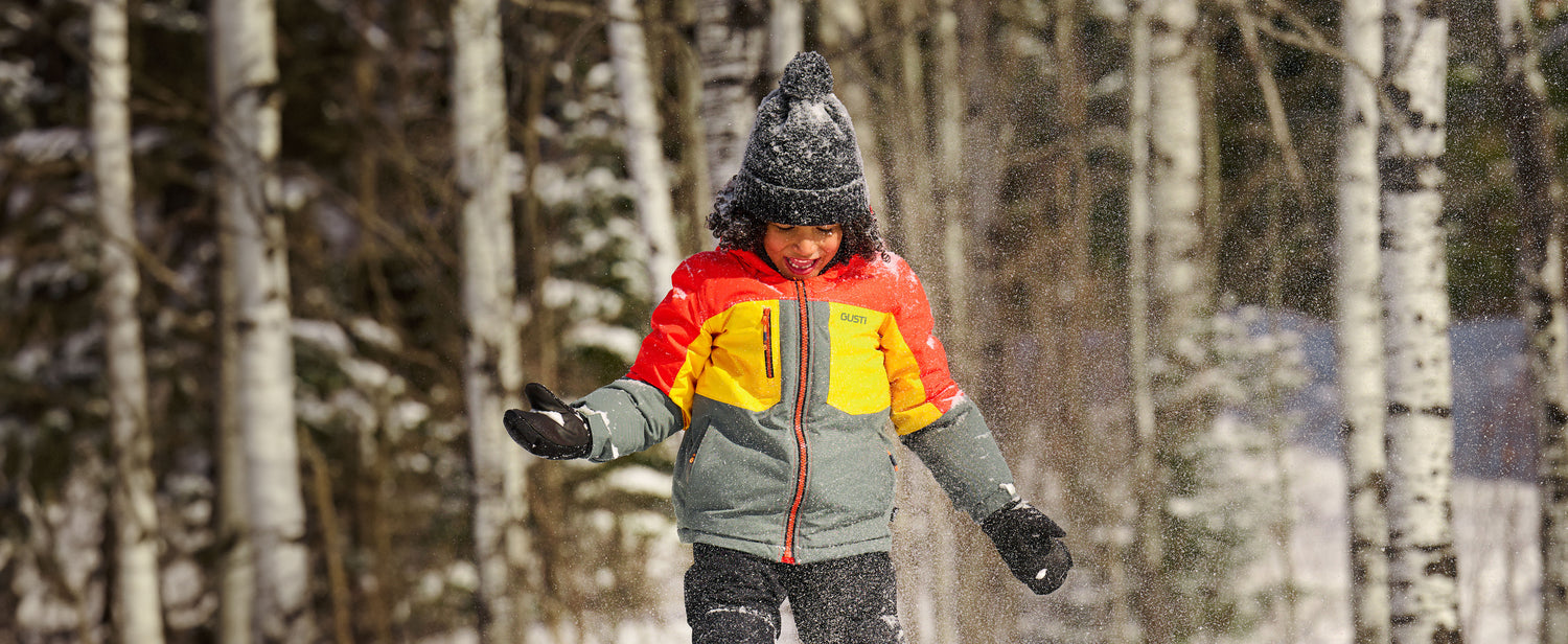 Child playing in the snow wearing Gusti winter gear